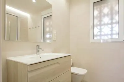 a bathroom with a sink and a toilet and a mirror at Apartamento a pie de playa in Cullera