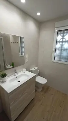 a bathroom with a sink and a toilet and a mirror at Apartamento a pie de playa in Cullera