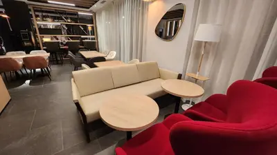 a living room with a couch and tables and chairs at Sercotel Plana Suites in Vall de Uixó