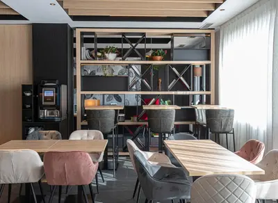 a restaurant with wooden tables and chairs and a shelf at Sercotel Plana Suites in Vall de Uixó