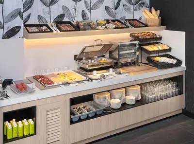 a buffet line with plates and food on display at Sercotel Plana Suites in Vall de Uixó