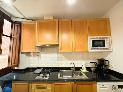 a kitchen with wooden cabinets and a sink at Apartamento con encanto histórico in Valencia