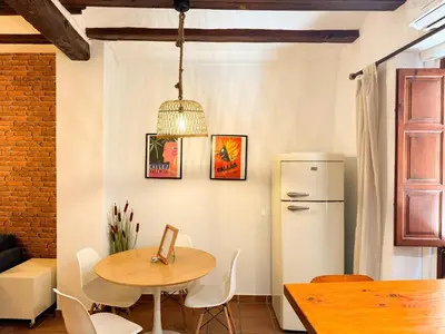 a dining room with a table and a refrigerator at Apartamento con encanto histórico in Valencia