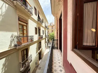an alley between two buildings with balconies at Apartamento con encanto histórico in Valencia