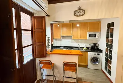 a kitchen with a counter and two stools at Apartamento con encanto histórico in Valencia