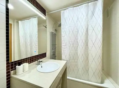 a bathroom with a sink and a shower and a mirror at Apartamento con piscina, padel y vistas al mar in Moncófar