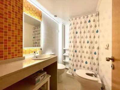 a bathroom with a sink and a toilet and a mirror at Apartamento con piscina, padel y vistas al mar in Moncófar