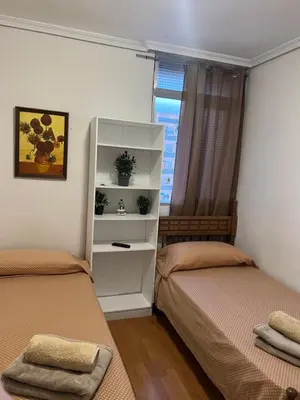 a bedroom with two beds and a book shelf at Malvarrosa habitación cómoda y sencilla cerca de la playa in Valencia