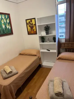 a room with two beds and a shelf with plants at Malvarrosa habitación cómoda y sencilla cerca de la playa in Valencia