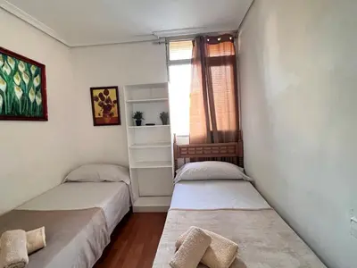 two beds in a room with a window at Malvarrosa habitación cómoda y sencilla cerca de la playa in Valencia