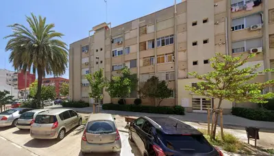 a parking lot with cars parked in front of a building at Malvarrosa habitación cómoda y sencilla cerca de la playa in Valencia