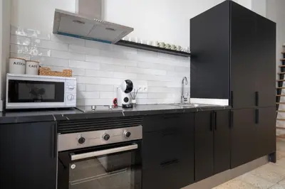 a kitchen with black cabinets and a microwave at Apartamento Menorca Apartamento n1 in Valencia
