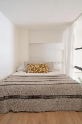a bed in a white room with a pillow on it at Loft Ibiza Apartamento n2 in Valencia