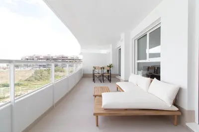 a living room with white furniture and a large window at Global Vacacional, Apartamento con terraza y vistas a la piscina en Gran Canet in Canet de Berenguer