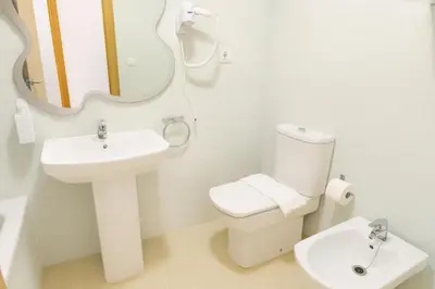a bathroom with a sink and a toilet and a mirror at Tu refugio en Canet, piscina, parking y playa in Canet de Berenguer