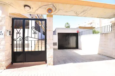 a black door on a building with a garage at Tu refugio en Canet, piscina, parking y playa in Canet de Berenguer