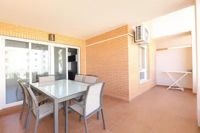 a dining room with a glass table and chairs at Tu refugio en Canet, piscina, parking y playa in Canet de Berenguer