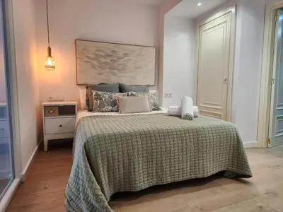 a bedroom with a large bed with a green blanket at FLORIT FLATS - The Apolo Apartment in Valencia