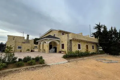 a large stone house with a large driveway at LA CASONA in Siete Aguas
