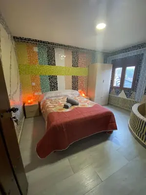 a bedroom with a bed with a red blanket at LA CASONA in Siete Aguas