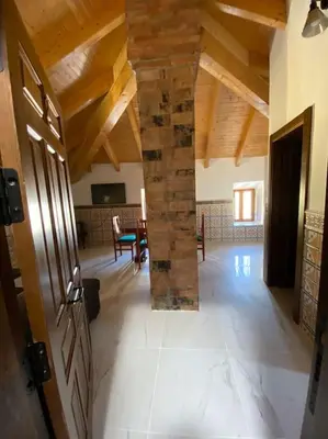 a living room with a stone pillar in a house at La carchata ático in Siete Aguas