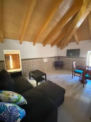 a living room with a couch and a table at La carchata ático in Siete Aguas