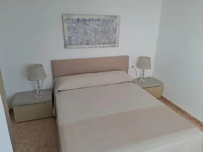 a bedroom with a large white bed and two lamps at Habitación familiar Portalet in Benaguacil