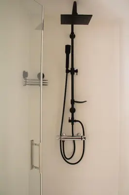 a shower with a cross hanging on a wall at Casa Mas Montañas in Godelleta