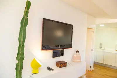 a flat screen tv hanging on a wall in a living room at Cullera Beach Apartment Cap Blanc in Cullera