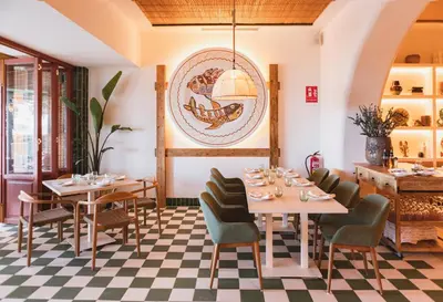 a restaurant with tables and chairs and a checkered floor at Casa Bassa Hotel in Valencia