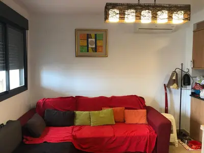 a red couch with colorful pillows sitting in a living room at FeWo - Moncofa Apartment in Moncófar