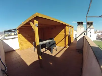a wooden building with a bench on a roof at FeWo - Moncofa Apartment in Moncófar