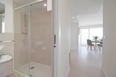 a glass shower in a bathroom with a table at Moderno apartamento con vistas a la costa mediterranea en Gran Canet in Canet de Berenguer