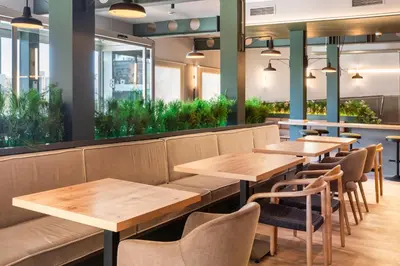 a row of tables and chairs in a restaurant at B&B HOTEL Valencia Aeropuerto in Paterna