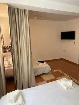 a room with two beds and a flat screen tv at Habitaciones con cocina y baño privado de temporada Vacaciones largas Long Stay desde 11 noches in Valencia