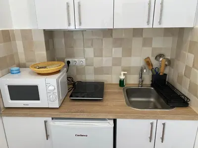 a kitchen counter with a microwave and a sink at Habitaciones con cocina y baño privado de temporada Vacaciones largas Long Stay desde 11 noches in Valencia
