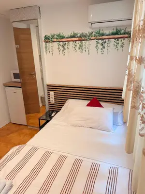a bedroom with a white bed with a red pillow at Habitaciones con cocina y baño privado de temporada Vacaciones largas Long Stay desde 11 noches in Valencia