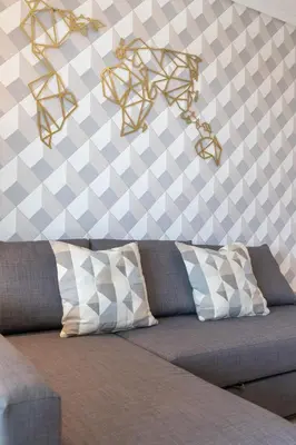 a couch in a room with a checkered wall at ApartUP Patacona Sunrise Duplex I in Valencia