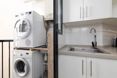 a kitchen with a washing machine and a sink at ApartUP Patacona Sunrise Duplex I in Valencia