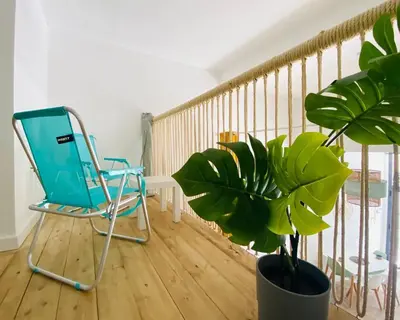 a blue chair and a potted plant on a balcony at B1 Verdeguer - Flat close to the Beach in Valencia