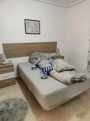a bedroom with a bed and a wooden headboard at Estrella playa in Puerto de Sagunto