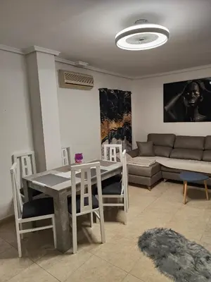 a living room with a table and chairs and a couch at Estrella playa in Puerto de Sagunto