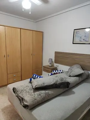 a bedroom with two beds and wooden cabinets at Estrella playa in Puerto de Sagunto
