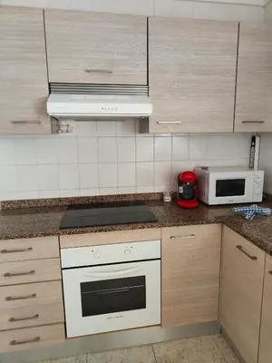 a kitchen with a white stove top oven next to a microwave at Estrella playa in Puerto de Sagunto