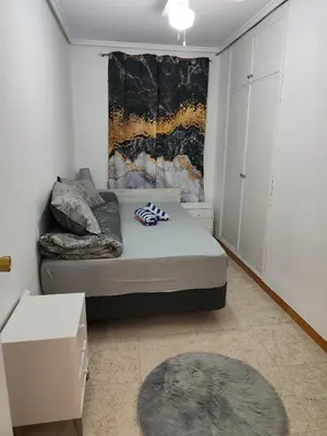 a small bedroom with a bed and a rug at Estrella playa in Puerto de Sagunto