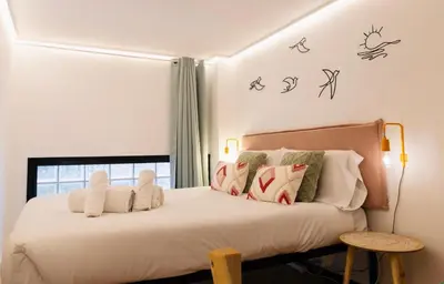 a bedroom with a bed with white sheets and birds on the wall at B2 Verdeguer - Cozy Loft close to the beach in Valencia