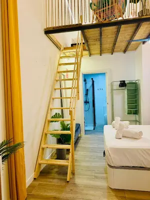 a wooden staircase in a room with two beds at B2 Verdeguer - Cozy Loft close to the beach in Valencia