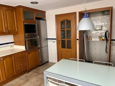 a kitchen with a table and a refrigerator at FRENTE AL MAR in Burriana