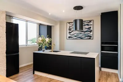 a kitchen with a black and white island with a sink at El Labrador in Anna