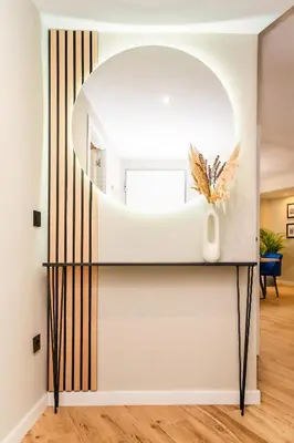 a mirror on a black console table in a living room at El Labrador in Anna
